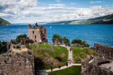 The ruins of Urquhart Castle overlook the deep blue waters of Loch Ness in the Highlands of Scotland.